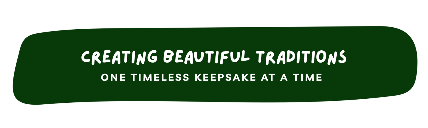 A dark green rounded banner with white text reading 'CREATING BEAUTIFUL TRADITIONS' and 'ONE TIMELESS KEEPSAKE AT A TIME' on a white background.