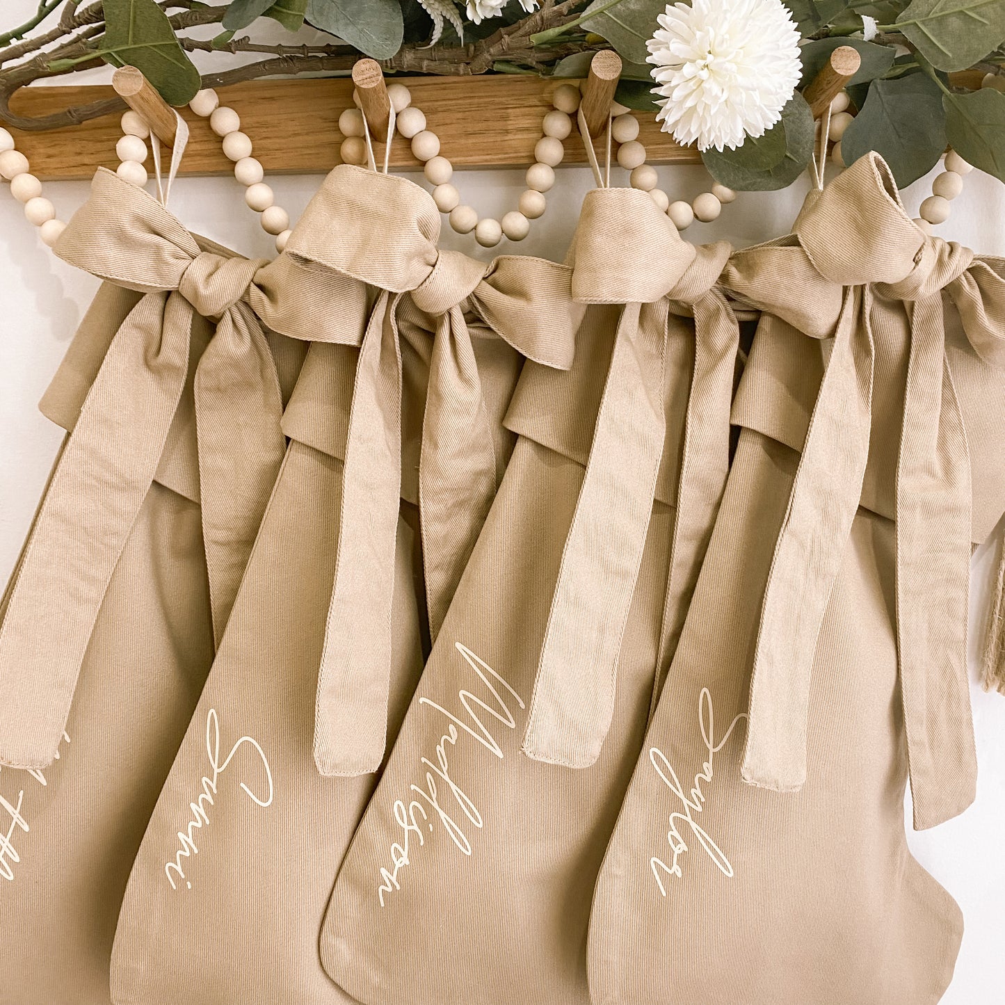 Personalised Christmas canvas bow stocking. Custom Christmas neutral stocking with bow. Minimalist bow Christmas stocking. Bow Name Christmas stocking. Personalised tan stocking with bow. Personalised cotton neutral bow stocking.