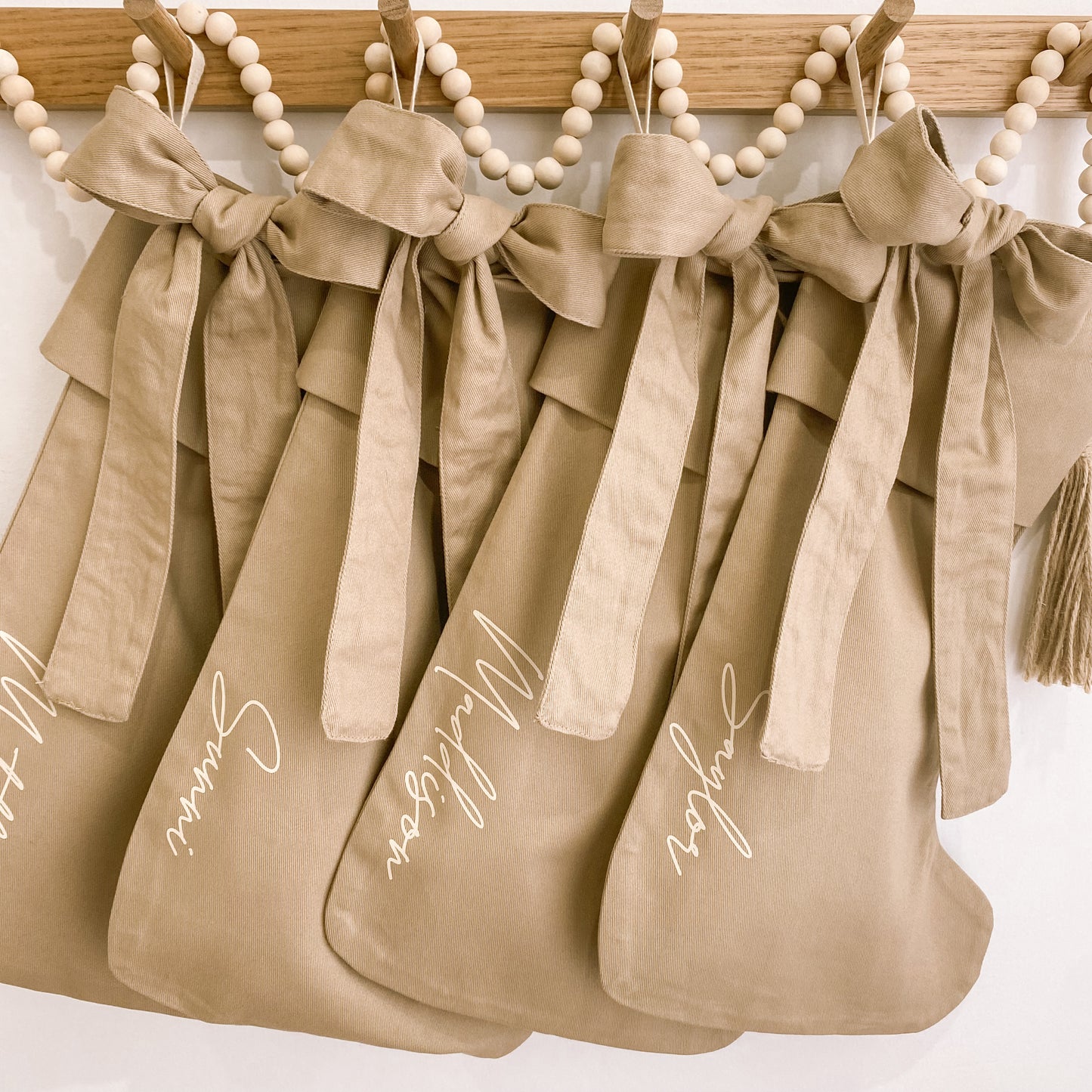 Personalised Christmas canvas bow stocking. Custom Christmas neutral stocking with bow. Minimalist bow Christmas stocking. Bow Name Christmas stocking. Personalised tan stocking with bow. Personalised cotton neutral bow stocking.