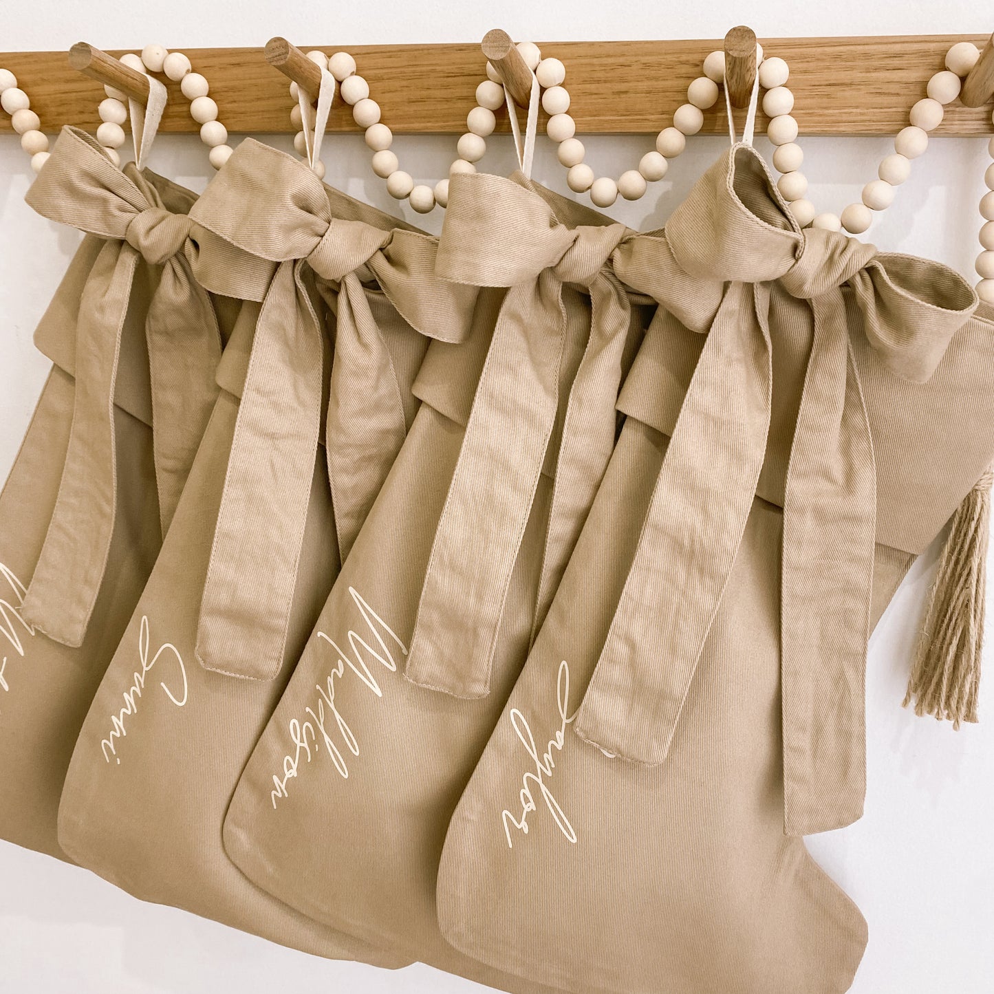 Personalised Christmas canvas bow stocking. Custom Christmas neutral stocking with bow. Minimalist bow Christmas stocking. Bow Name Christmas stocking. Personalised tan stocking with bow. Personalised cotton neutral bow stocking.