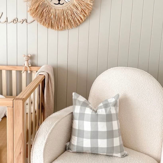 Green gingham cushion cover styled in neutral nursery