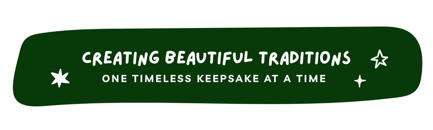 A dark green rounded banner with white text reading 'CREATING BEAUTIFUL TRADITIONS' and 'ONE TIMELESS KEEPSAKE AT A TIME', decorated with small white stars on a white background.