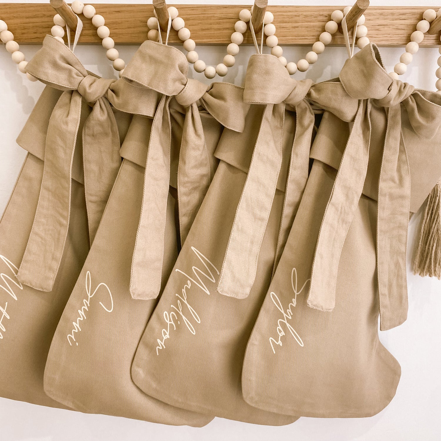 Personalised Christmas canvas bow stocking. Custom Christmas neutral stocking with bow. Minimalist bow Christmas stocking. Bow Name Christmas stocking. Personalised tan stocking with bow. Personalised cotton neutral bow stocking.