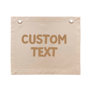 A beige canvas banner with two metal grommets at the top corners and the words 'CUSTOM TEXT' printed in a brownish-tan font in the center, shown on a plain white background.